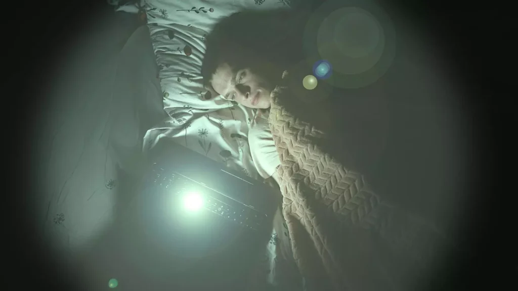 Chico tumbado en la cama con un portátil